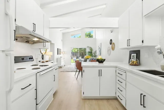 a kitchen with white cabinets and white appliances