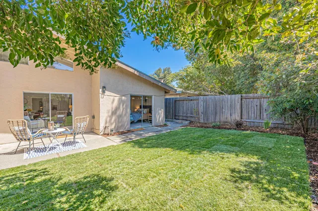 a view of a chair and table in backyard of the house