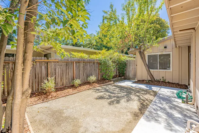 a backyard of a house with table and chairs