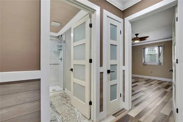 a view of a hallway with wooden floor and staircase