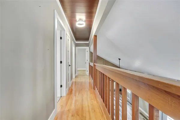 a view of a hallway with wooden floor and staircase