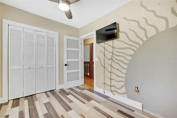 a view of a livingroom with wooden floor and a ceiling fan