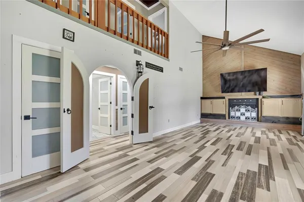 a view of a livingroom with wooden floor and a ceiling fan