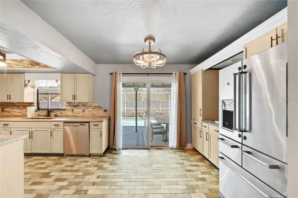 a kitchen with stainless steel appliances granite countertop a refrigerator oven a sink dishwasher and white cabinets with wooden floor