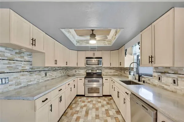 a kitchen with stainless steel appliances granite countertop a sink stove and cabinets