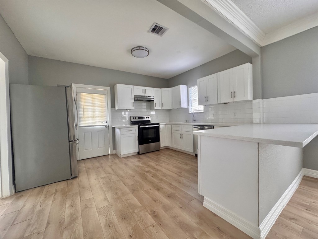 4106 Robertson Street Houston, TX 77009 - Photo 7 of 14 a kitchen with white cabinets and stainless steel appliances