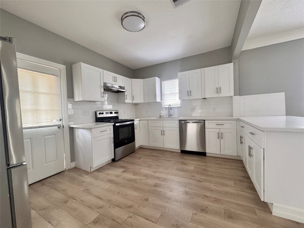 4106 Robertson Street Houston, TX 77009 - Photo 8 of 14 a kitchen with white cabinets stainless steel appliances and a window