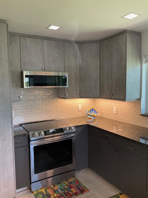 224 Cardinal Lane Delray Beach, FL 33445 - Photo 15 of 38 a kitchen with granite countertop a stove and a sink