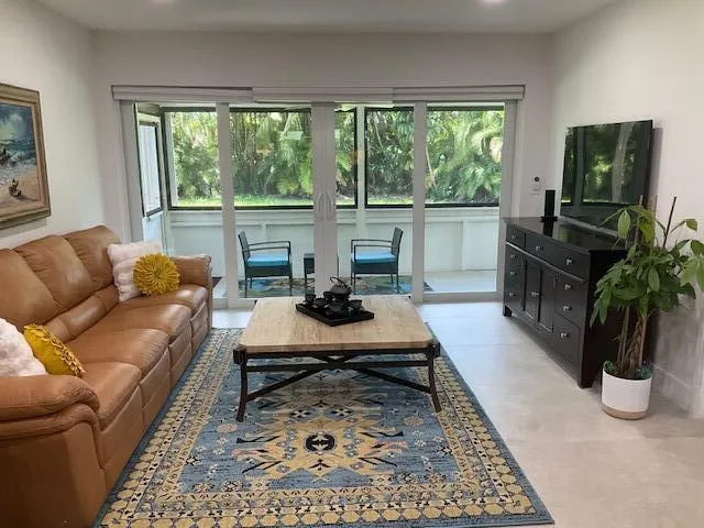 a living room with furniture tv and a large window