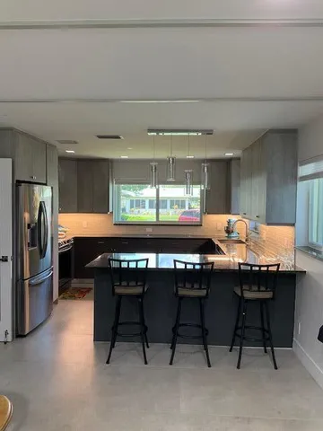 a kitchen with a table chairs and refrigerator
