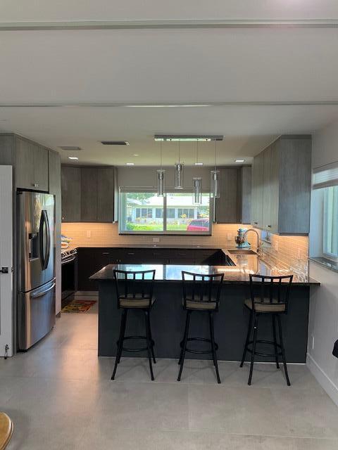 224 Cardinal Lane Delray Beach, FL 33445 - Photo 8 of 38 a kitchen with a table chairs and refrigerator