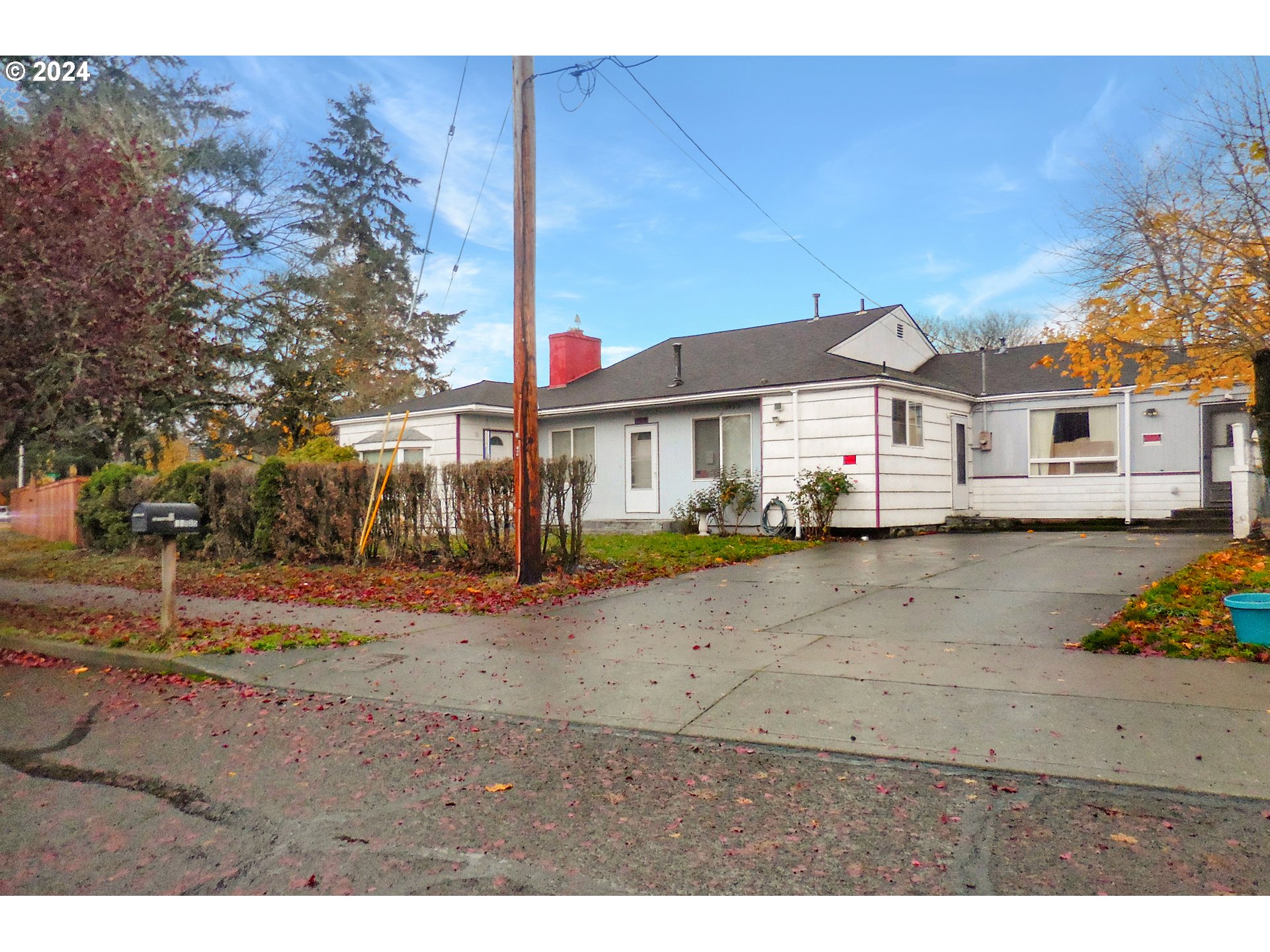 11535 Southeast Boise Street Portland, OR 97266 - Photo 3 of 10 a view of a large white house with a yard and table and chairs under an umbrella