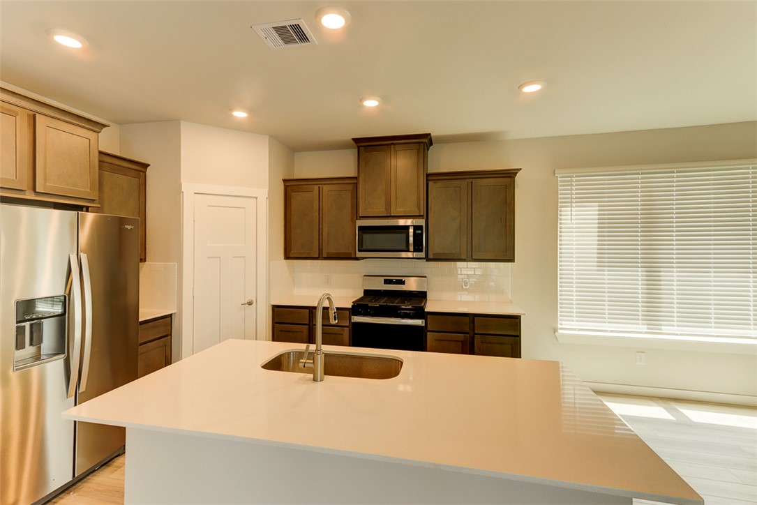 760 Double Mountain Road College Station, TX 77845 - Photo 6 of 26 a kitchen with stainless steel appliances a refrigerator stove microwave and sink