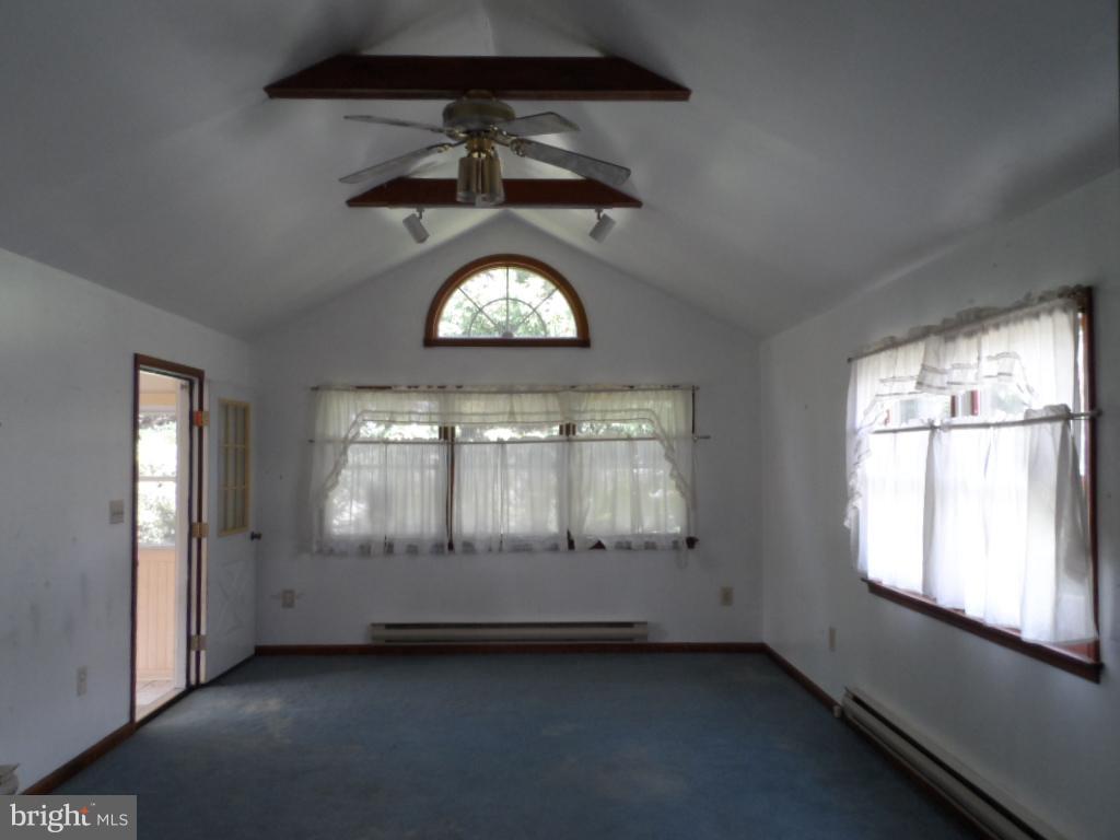 914 Bardswell Road Baltimore, MD 21228 - Photo 3 of 10 an empty room with a ceiling fan and a window