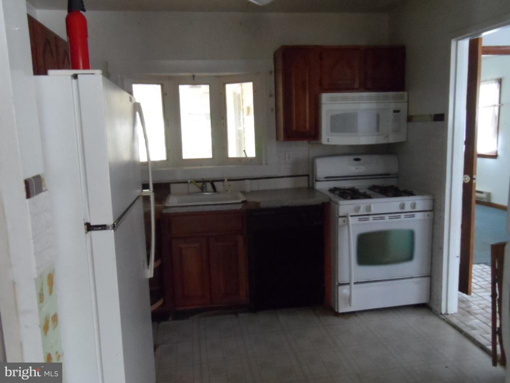 914 Bardswell Road Baltimore, MD 21228 - Photo 6 of 10 a kitchen with a stove and a microwave