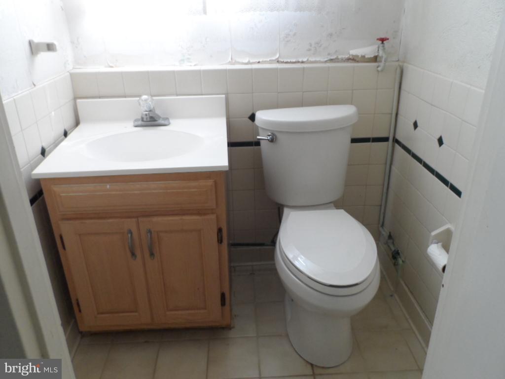 914 Bardswell Road Baltimore, MD 21228 - Photo 7 of 10 a white toilet sitting next to a bathroom sink