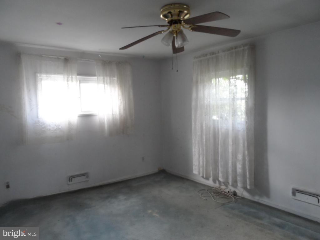 914 Bardswell Road Baltimore, MD 21228 - Photo 10 of 10 an empty room with windows and chandelier fan