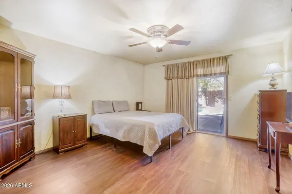 a spacious bedroom with a bed and wooden floor