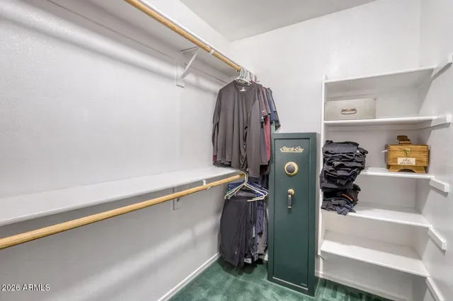 a view of walk in closet with clothes and shoes