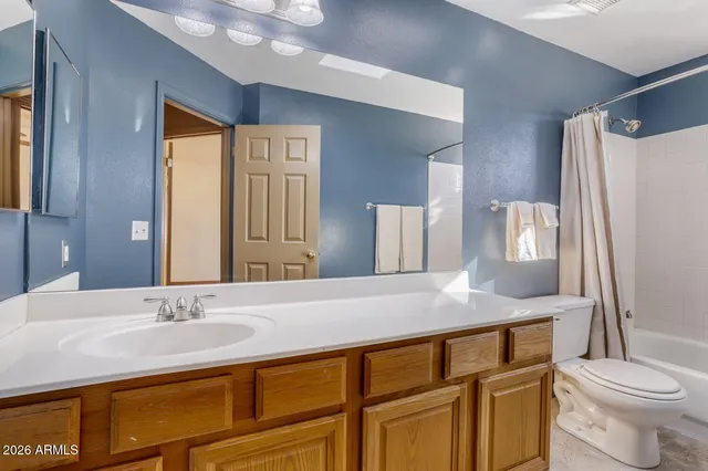 a bathroom with a granite countertop sink toilet and mirror