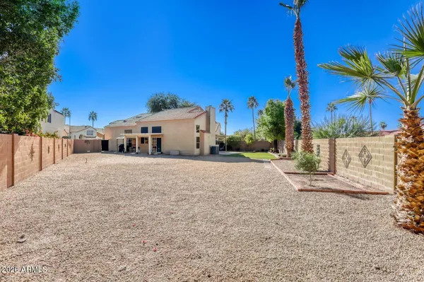 a view of a house with palm trees and a small yard