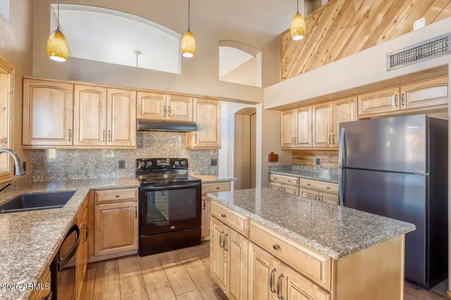 a kitchen with stainless steel appliances granite countertop a sink stove and refrigerator