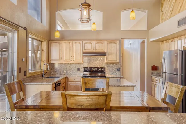 a kitchen with stainless steel appliances granite countertop a sink and a refrigerator