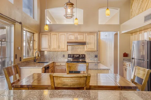 a kitchen with stainless steel appliances granite countertop a sink and a refrigerator