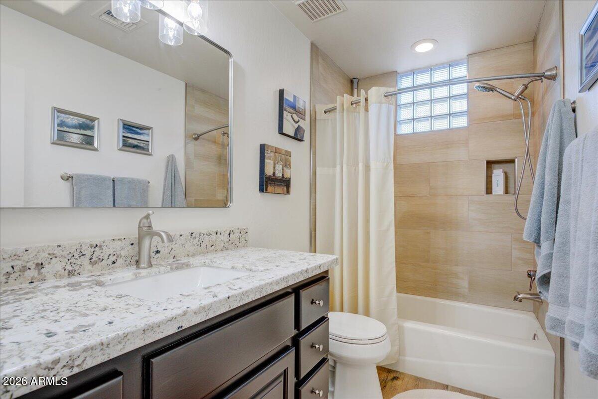27901 Tranquilo Way Rio Verde, AZ 85263 - Photo 17 of 35 a bathroom with a granite countertop sink a toilet a mirror a shower and bathtub