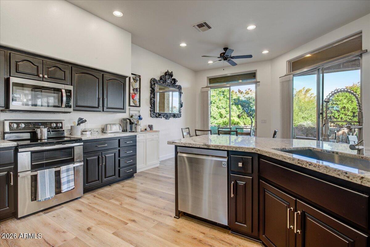 27901 Tranquilo Way Rio Verde, AZ 85263 - Photo 10 of 35 a kitchen with stainless steel appliances granite countertop a sink stove and microwave