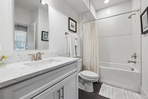 a kitchen with stainless steel appliances granite countertop a sink a stove a refrigerator and island with wooden floor