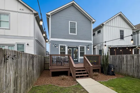a view of a house with wooden deck and furniture