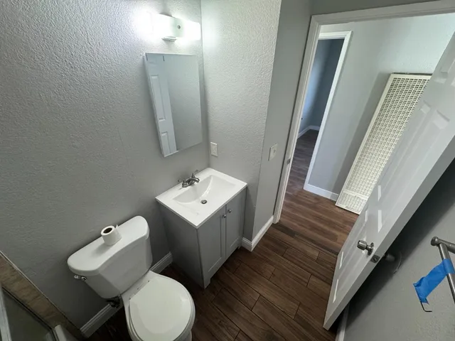 a bathroom with a toilet sink and mirror