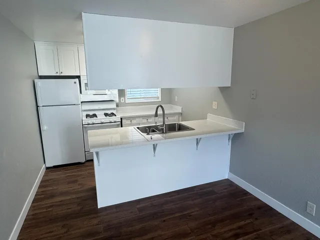 a kitchen with a sink cabinets and wooden floor