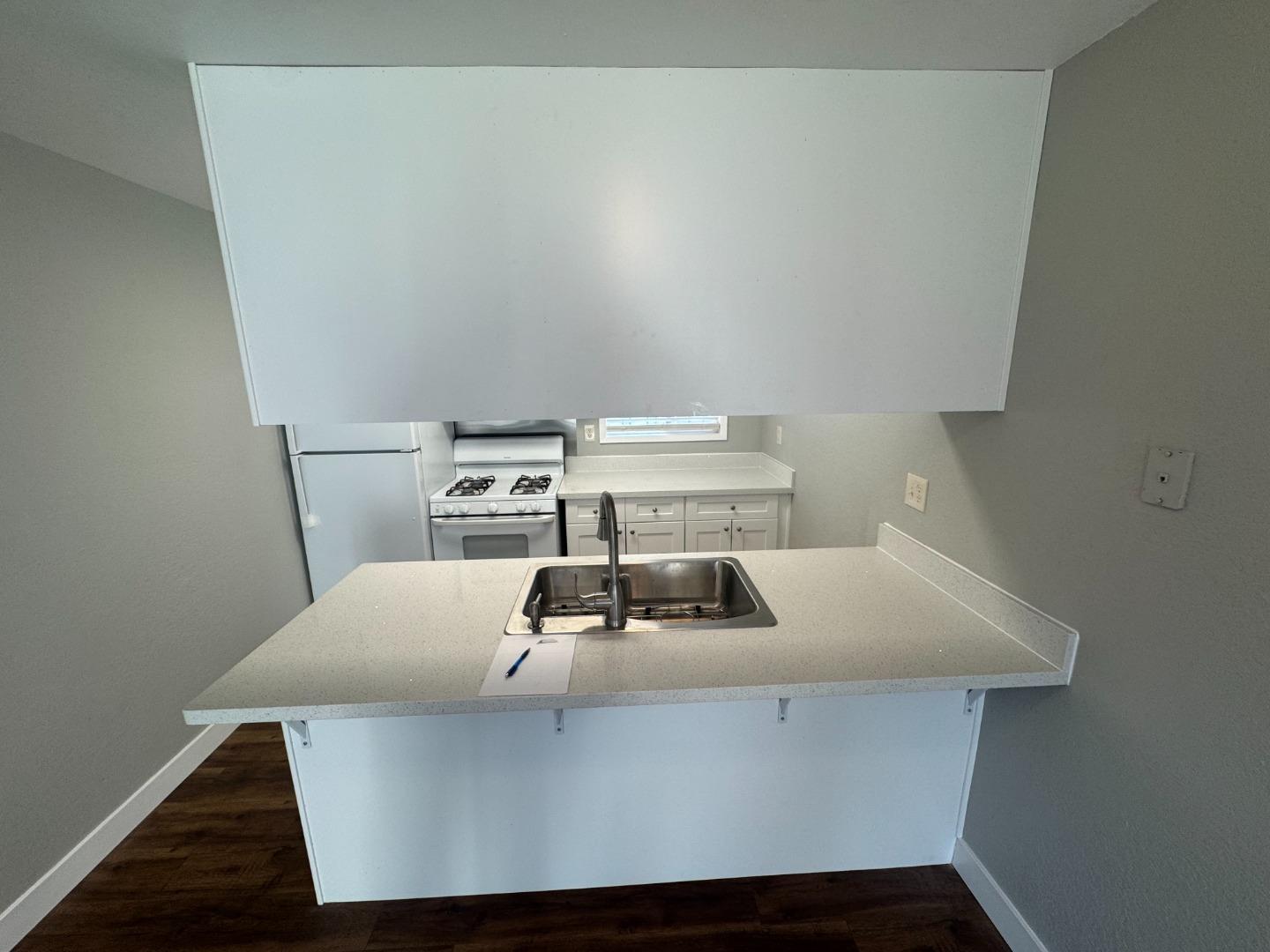 1051 Rider Avenue, Unit F Salinas, CA 93905 - Photo 7 of 23 a kitchen with a sink a stove and white cabinets