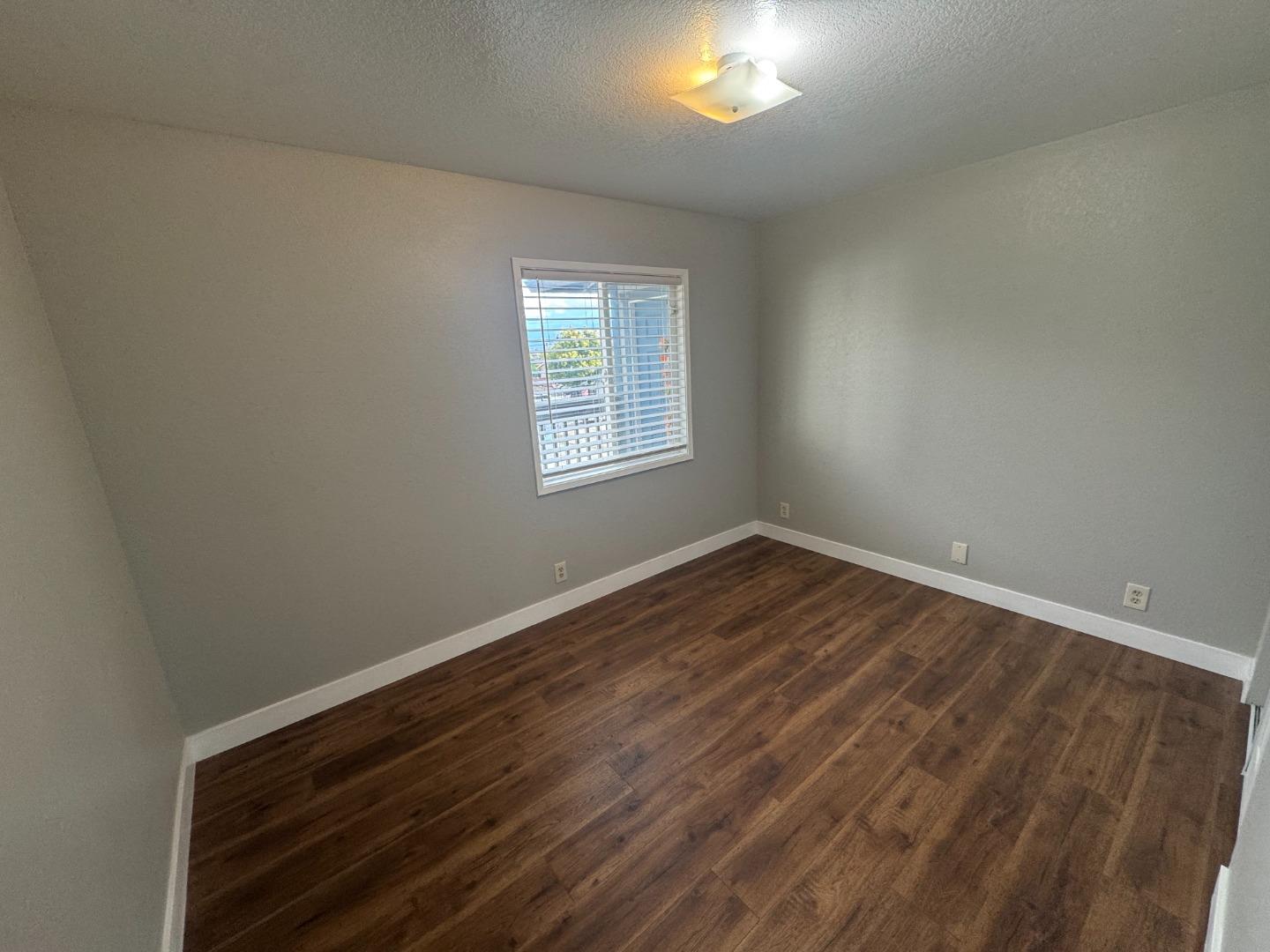 1051 Rider Avenue, Unit F Salinas, CA 93905 - Photo 8 of 23 an empty room with wooden floor and windows