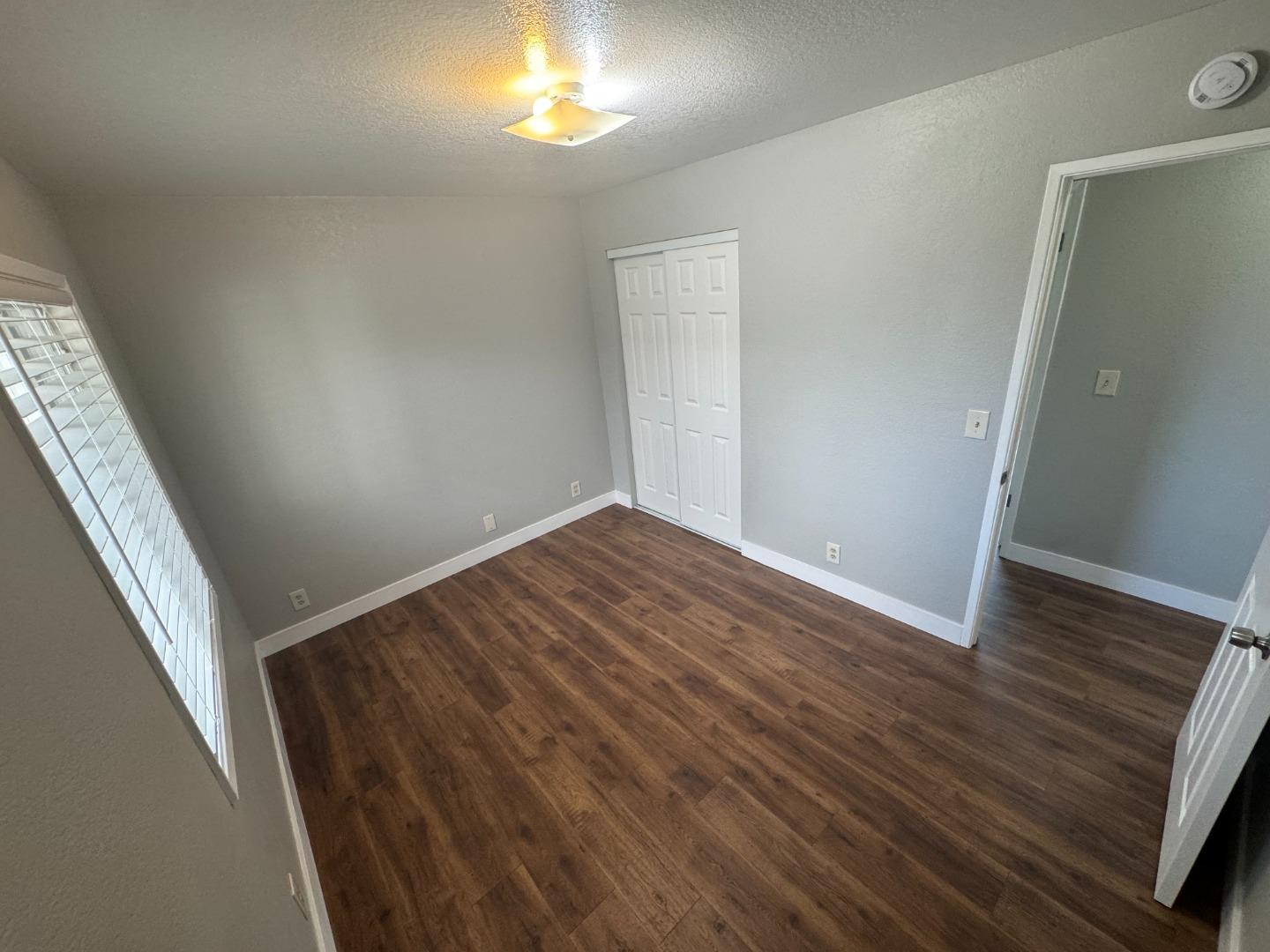 1051 Rider Avenue, Unit F Salinas, CA 93905 - Photo 10 of 23 an empty room with wooden floor and windows
