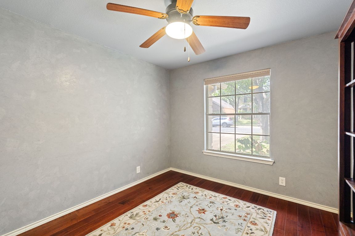 2114 Desco Drive Austin, TX 78748 - Photo 14 of 40 Unfurnished room with dark wood-type flooring, a ceiling fan, and baseboards