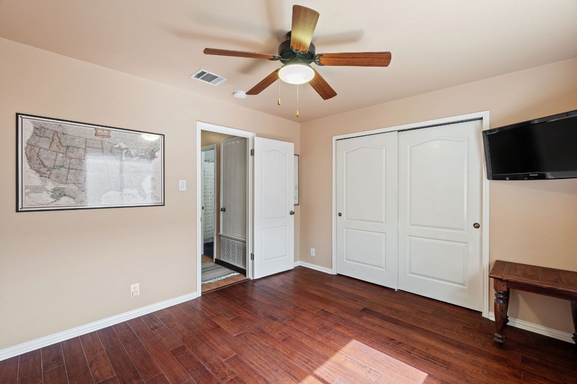 2114 Desco Drive Austin, TX 78748 - Photo 20 of 40 Unfurnished bedroom featuring dark wood-type flooring, baseboards, a closet, and a ceiling fan