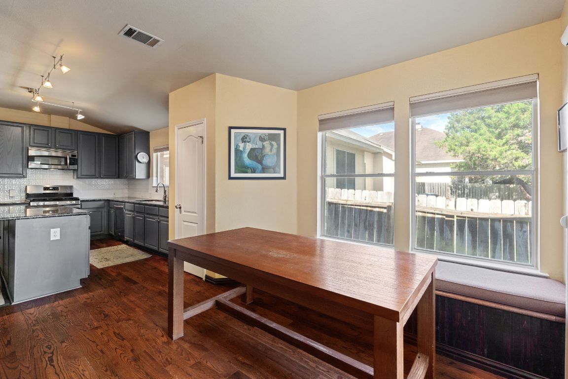 2114 Desco Drive Austin, TX 78748 - Photo 24 of 40 Kitchen with stainless steel appliances, a sink, gray cabinetry, dark wood-style flooring, and vaulted ceiling
