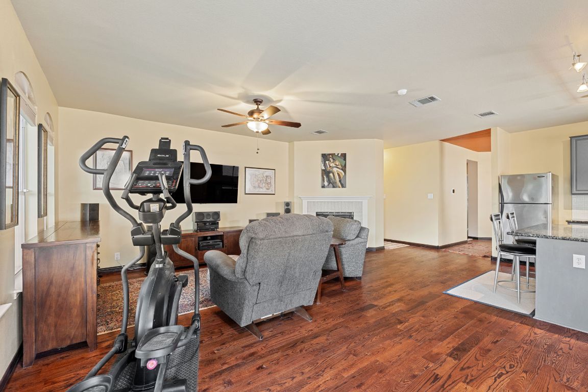 2114 Desco Drive Austin, TX 78748 - Photo 26 of 40 Living area with a ceiling fan, dark wood-style flooring, a fireplace, and baseboards