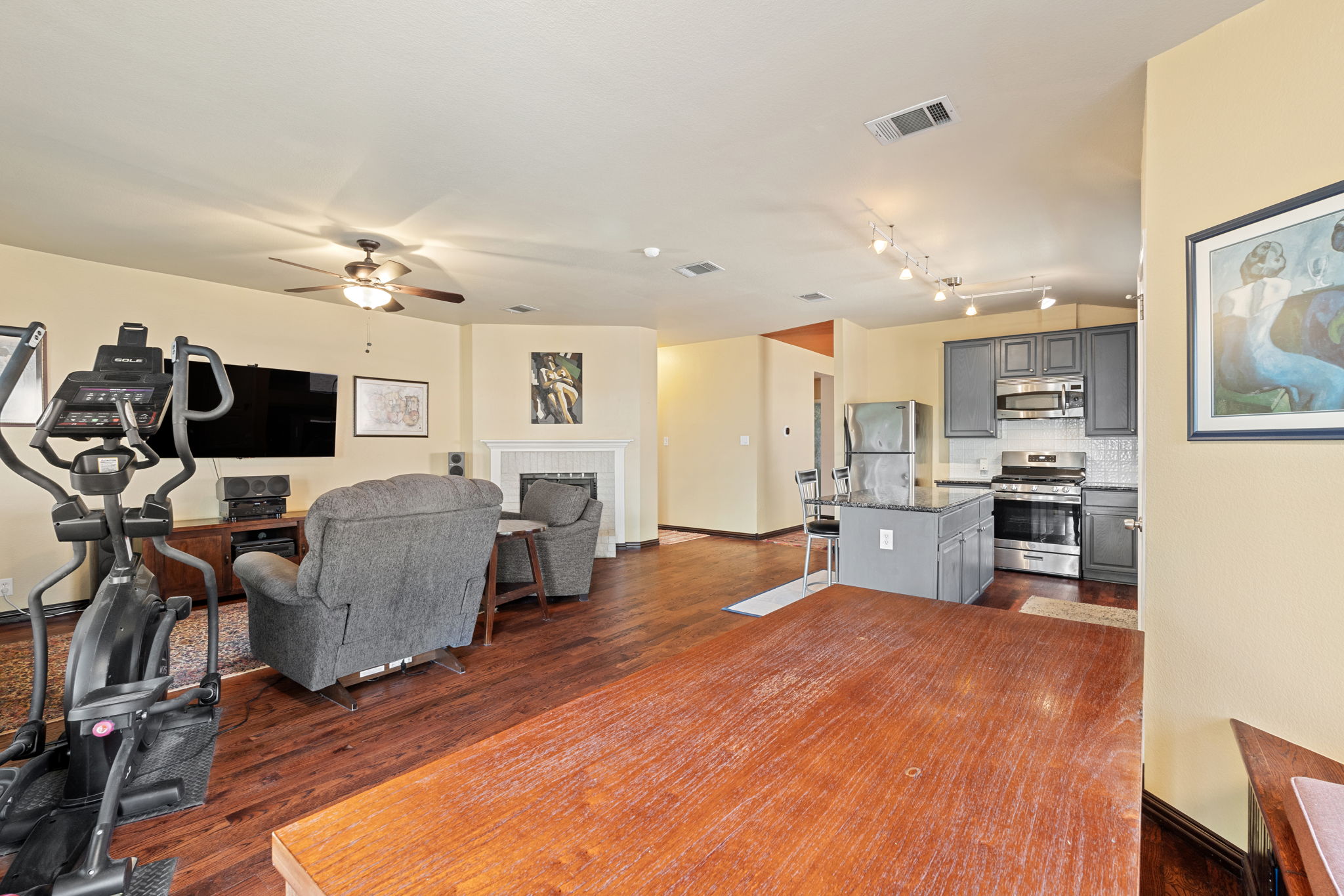 2114 Desco Drive Austin, TX 78748 - Photo 28 of 40 Living area featuring dark wood-type flooring, a ceiling fan, a brick fireplace, and baseboards