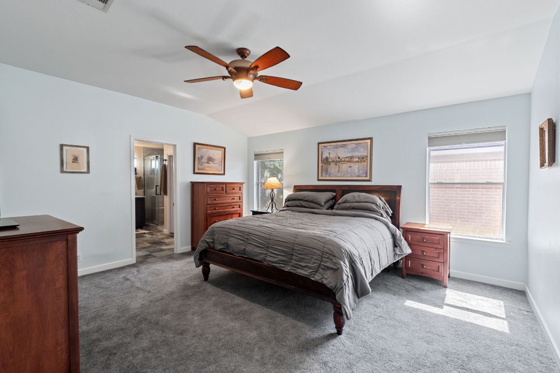 2114 Desco Drive Austin, TX 78748 - Photo 30 of 40 Bedroom with carpet, baseboards, lofted ceiling, ceiling fan, and connected bathroom