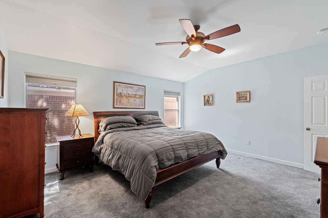 2114 Desco Drive Austin, TX 78748 - Photo 34 of 40 Bedroom featuring lofted ceiling, carpet, baseboards, and a ceiling fan