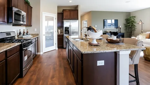 a kitchen with granite countertop stainless steel appliances and wooden floor