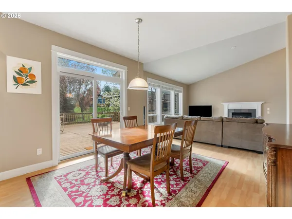 a dining room with furniture a floor to ceiling window and wooden floor
