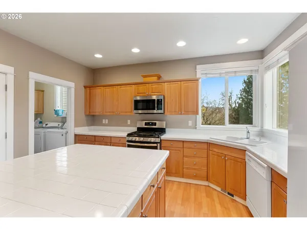 a kitchen with stainless steel appliances kitchen island granite countertop a sink and cabinets
