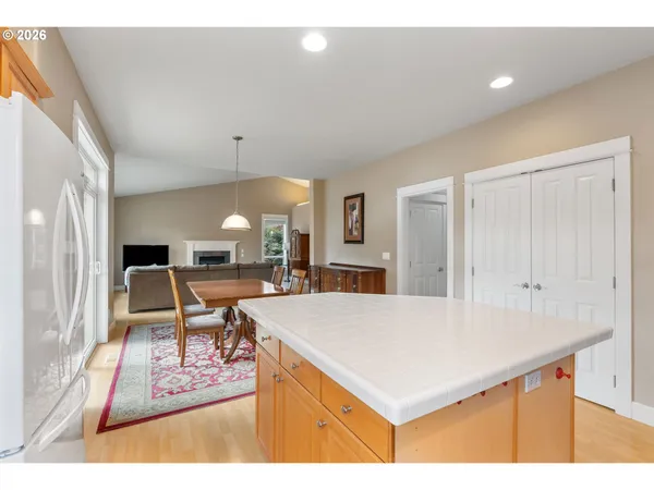 a living room with a table chairs and a kitchen view