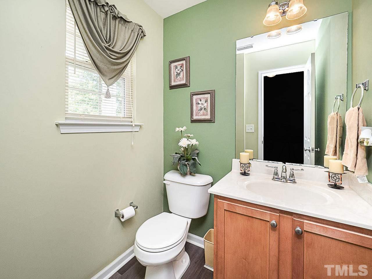 5833 Bryanstone Place Raleigh, NC 27610 - Photo 14 of 25 a bathroom with a sink a mirror and a toilet