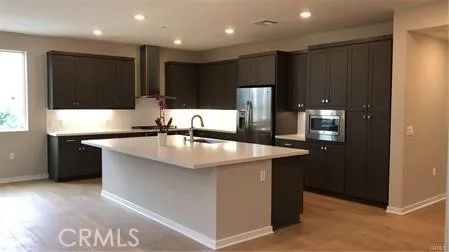 a kitchen with kitchen island granite countertop a sink and a refrigerator